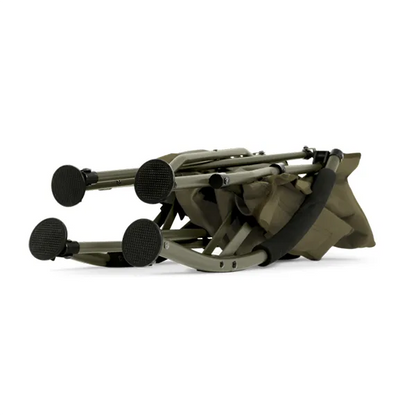 A folded olive green camping chair with black textured foot pads and a black carrying strap, shown on a plain white background.